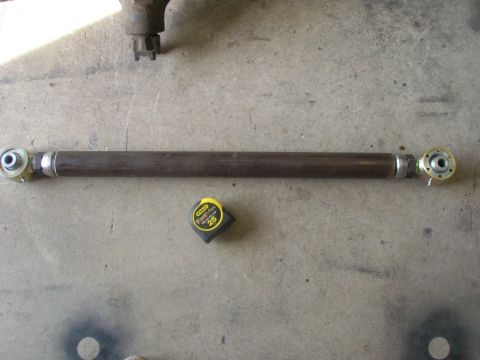 1996 Ford Bronco - A fabricated adjustable control arm with heim joints on each end is laid out on a concrete surface next to a yellow Stanley tape measure. A…