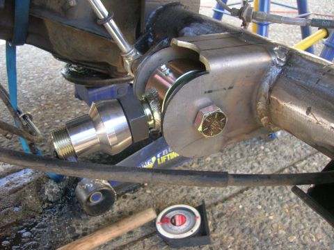 1996 Ford Bronco - A close-up view of a custom suspension component, likely part of a rear axle modification, on a vehicle. The part features a large metal br…
