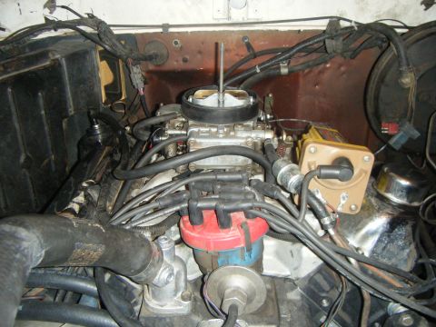 1979 Ford Bronco - This is a close-up view of the engine bay of a 1979 Ford Bronco, focusing on the carburetor, distributor, and spark plug wires. The engine…
