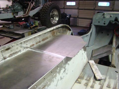 1948 Jeep Wrangler - A partially disassembled vehicle chassis is shown, with new sheet metal being fitted to the floor pan area. Tools and parts are visible on…