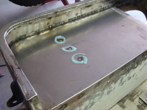 1948 Jeep Wrangler - Close-up of a metal panel undergoing repair, showing welding and sealant application.