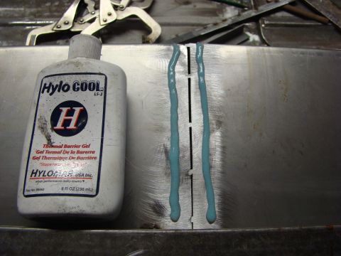 1948 Jeep Wrangler - A bottle of thermal barrier gel is placed next to a metal surface marked with blue gel, likely for a welding project.