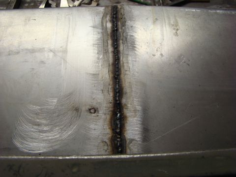 1948 Jeep Wrangler - A close-up view of a metal panel a prominent weld seam and evidence of grinding.
