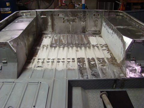 1948 Jeep Wrangler - The interior of a vintage Jeep tub is shown, stripped down and prepped for restoration. The metal floor and sides are exposed, revealing so…