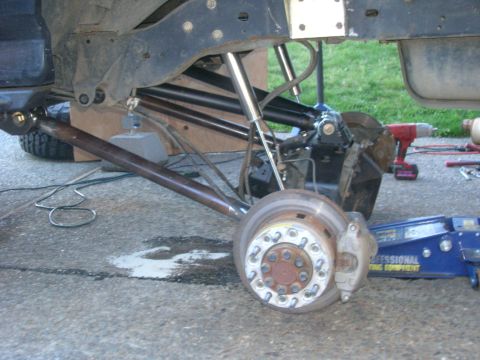 1996 Ford Bronco - The rear suspension of a lifted 1996 Ford Bronco is shown with the wheel removed, revealing the brake rotor, caliper, and heavy-duty suspen…