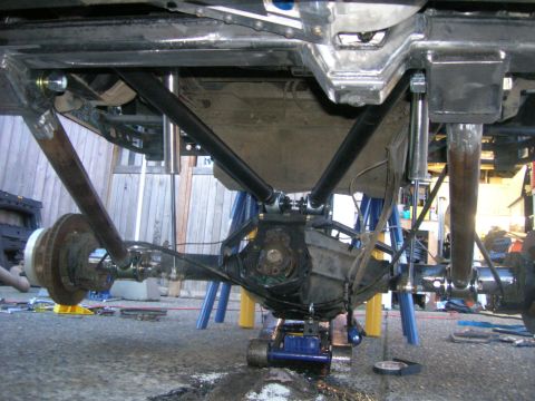 1996 Ford Bronco - The underside of a vehicle, likely a 1996 Ford Bronco, shows a modified suspension system with prominent aftermarket control arms and shock…