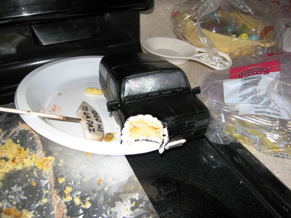 Black Bronco cake with a bite taken out, on a plate with cake crumbs