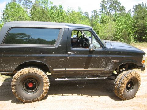 1995 Ford Bronco - This lifted Ford Bronco is covered in mud, suggesting it has been off-roading.