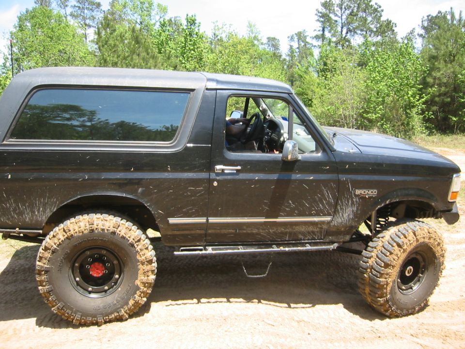 Black Ford Bronco with lifted suspension and large tires, side view