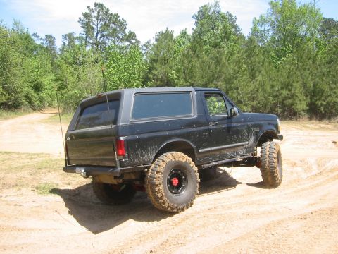 1995 Ford Bronco - This lifted 1995 Ford Bronco navigates a dusty trail, its off-road capabilities.