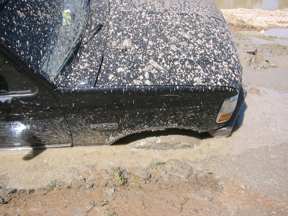 Black 1995 Ford Bronco stuck in mud, side view