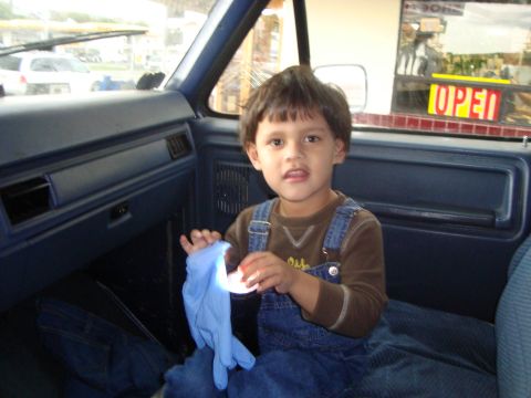 1986 Ford Bronco - A young child sits in the interior of a 1986 Ford Bronco, holding a blue glove.