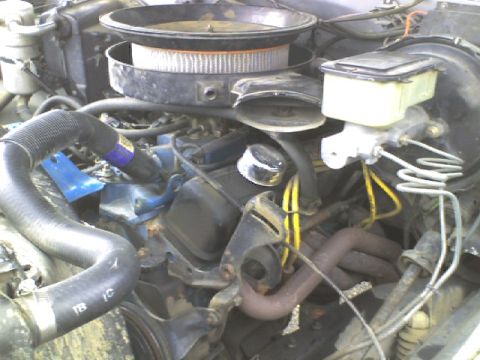 1988 Chevrolet Suburban - The engine bay of a 1988 Chevrolet Suburban shows the air filter, brake fluid reservoir, and exhaust manifold.