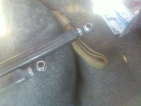 1992 Ford F-350 - A close-up view of a vehicle's suspension part, possibly a tie rod end, resting on a carpeted surface.