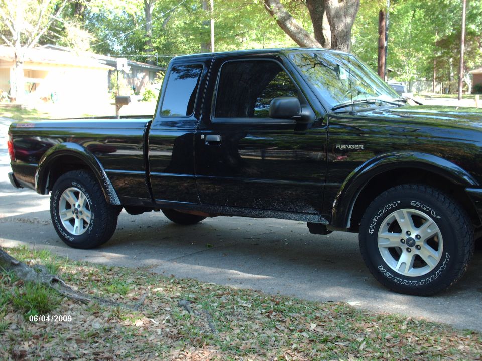 Black Ford Ranger pickup truck, side view. Has "Ranger" badge on fender