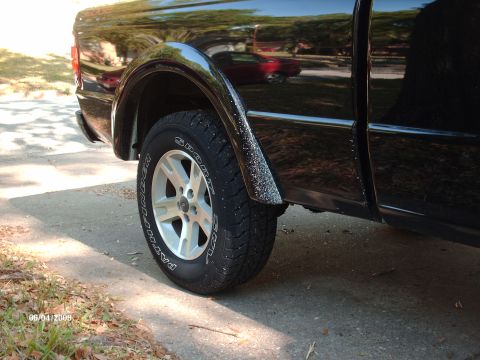 1990 Ford F-150 - A close-up view of the rear wheel well of a black pickup truck, showing the tire and alloy wheel. The image is dated June 4, 2009.