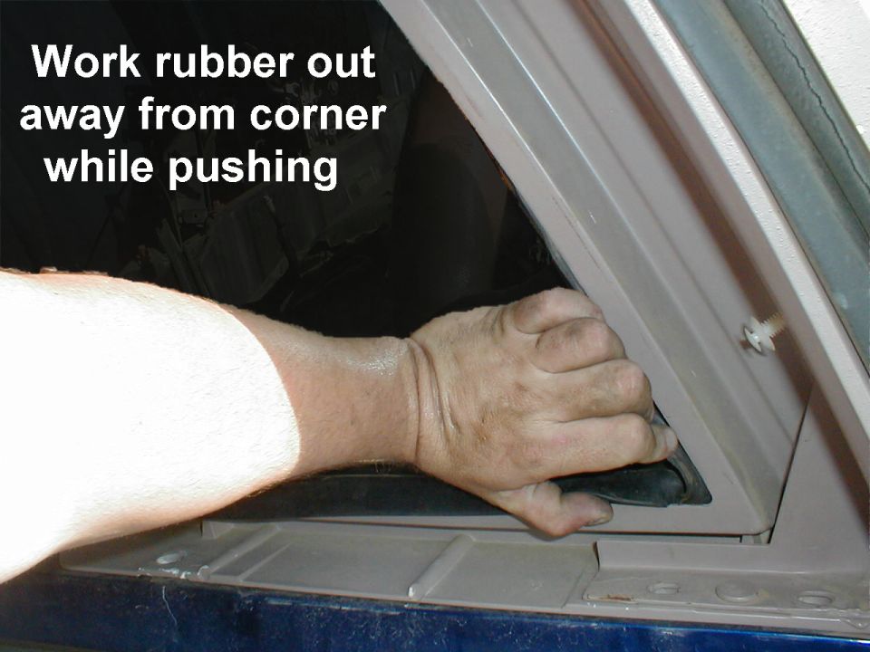 Work up & down the length of the glass so it doesn't shatter.  Tucking the corner out will help maintain progress.

Push as close as possible to the EDGE of the glass; pushing in the middle will shatter it.  If you're not sure, WEAR GLOVES.