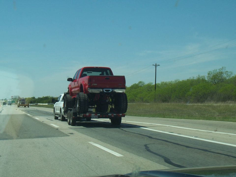 Red pickup truck on a trailer, rear view