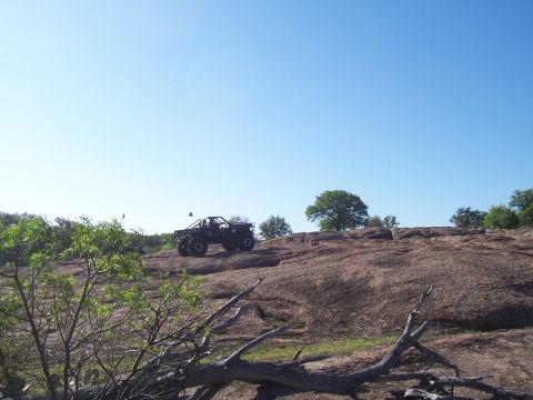 2004 Aston Martin Virage - A off-road vehicle navigates a rocky landscape on a clear day.