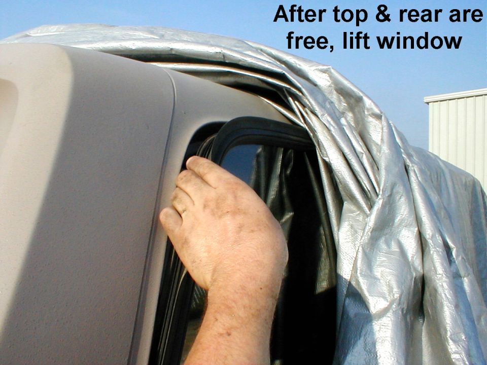 Hand lifting rear window from silver-tarped vehicle, text After top & rear are free lift window