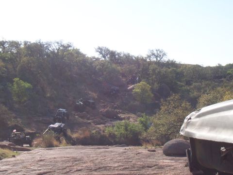 2004 Aston Martin Virage - Off-road vehicles tackle a challenging rocky terrain on a sunny day.