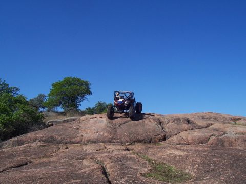 2004 Aston Martin Virage - An off-road buggy navigates a rocky landscape on a clear day.