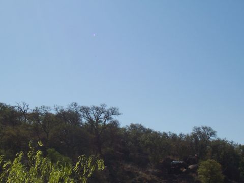 2004 Aston Martin Virage - SUV parked on a rocky hillside under a clear blue sky.