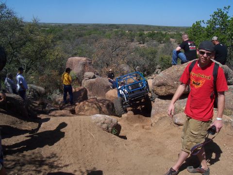 2004 Aston Martin Virage - An off-road buggy navigates a challenging rocky terrain with onlookers observing the action.