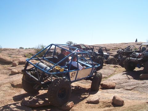 2004 Aston Martin Virage - Off-road buggies tackle challenging rocky terrain on a sunny day.