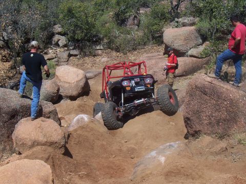 2004 Aston Martin Virage - Custom off-road buggy tackling a difficult rocky trail with spectators.