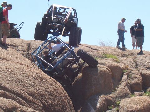 2004 Aston Martin Virage - Off-road vehicles tackle challenging terrain with spectators observing the action.