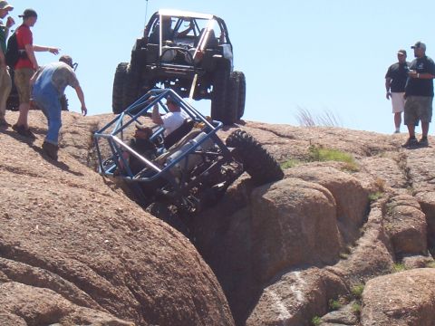 2004 Aston Martin Virage - Spectators watch as extreme off-road vehicles tackle a challenging rock climbing course.