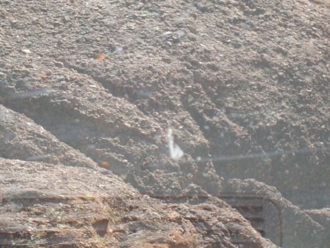 2004 Aston Martin Virage - A close-up view of a large pile of dirt and debris, with some horizontal elements in the lower portion.