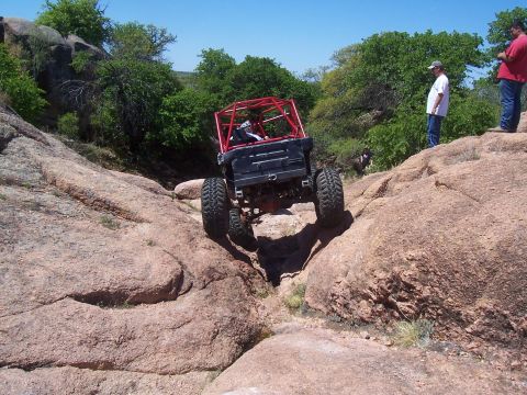 2004 Aston Martin Virage - This heavily modified off-road vehicle navigates a challenging rocky terrain.