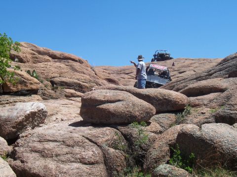 2004 Aston Martin Virage - Two off-road vehicles traverse a , rocky landscape on a sunny day.
