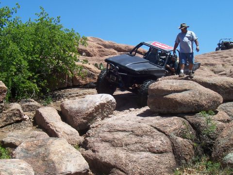 2004 Aston Martin Virage - A modified off-road buggy tackles a challenging rocky trail with another vehicle visible in the background.