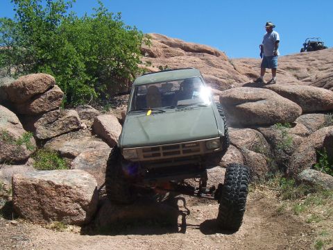 2004 Aston Martin Virage - This vehicle is attempting to traverse a difficult rocky terrain under a clear blue sky.