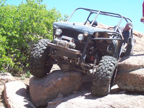 2004 Aston Martin Virage - This heavily modified buggy is navigating a challenging rocky terrain.