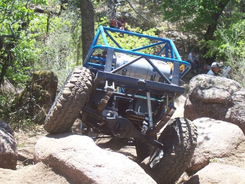 2004 Aston Martin Virage - A heavily modified off-road buggy is shown traversing a challenging rocky landscape.