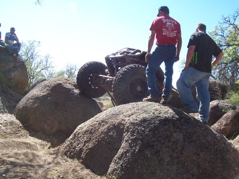 2004 Aston Martin Virage - An off-road buggy navigates a rocky terrain with two spectators observing the challenging climb.
