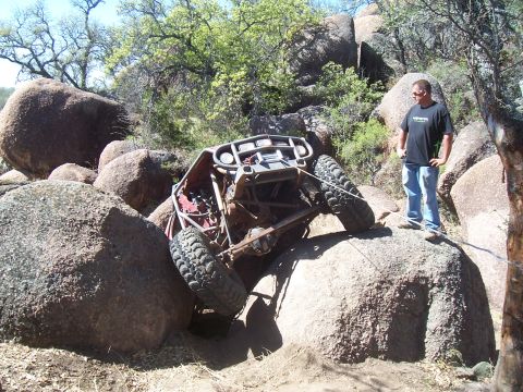 2004 Aston Martin Virage - An off-road buggy is navigating a challenging rocky terrain, with a person observing the situation.