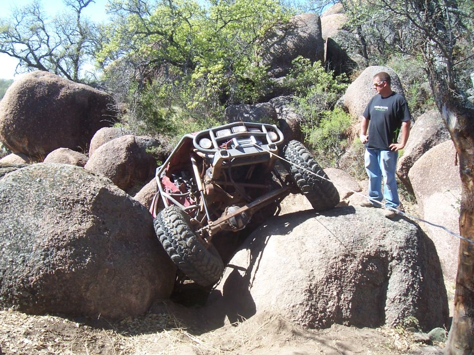 Buggy stuck on large rocks with a guy watching