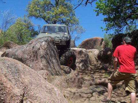 2004 Aston Martin Virage - Off-road vehicle tackling a challenging rocky trail on a sunny day.