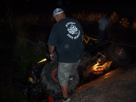 2004 Aston Martin Virage - An off-road vehicle lies on its side in the dark, with onlookers present.