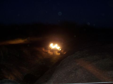 2004 Aston Martin Virage - The bright lights of a vehicle are visible in the darkness, creating a blurred effect.