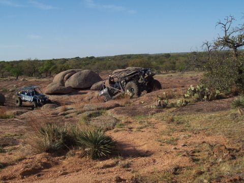2004 Aston Martin Virage - Off-road vehicles tackle challenging rocky terrain in a scenic, arid environment.