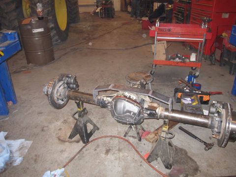 1992 Ford Bronco - Photograph of an axle assembly resting on jack stands in a shop, not a document.