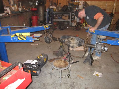 1992 Ford Bronco - Photograph of a technician assembling an axle on a stand in a workshop, not a document.