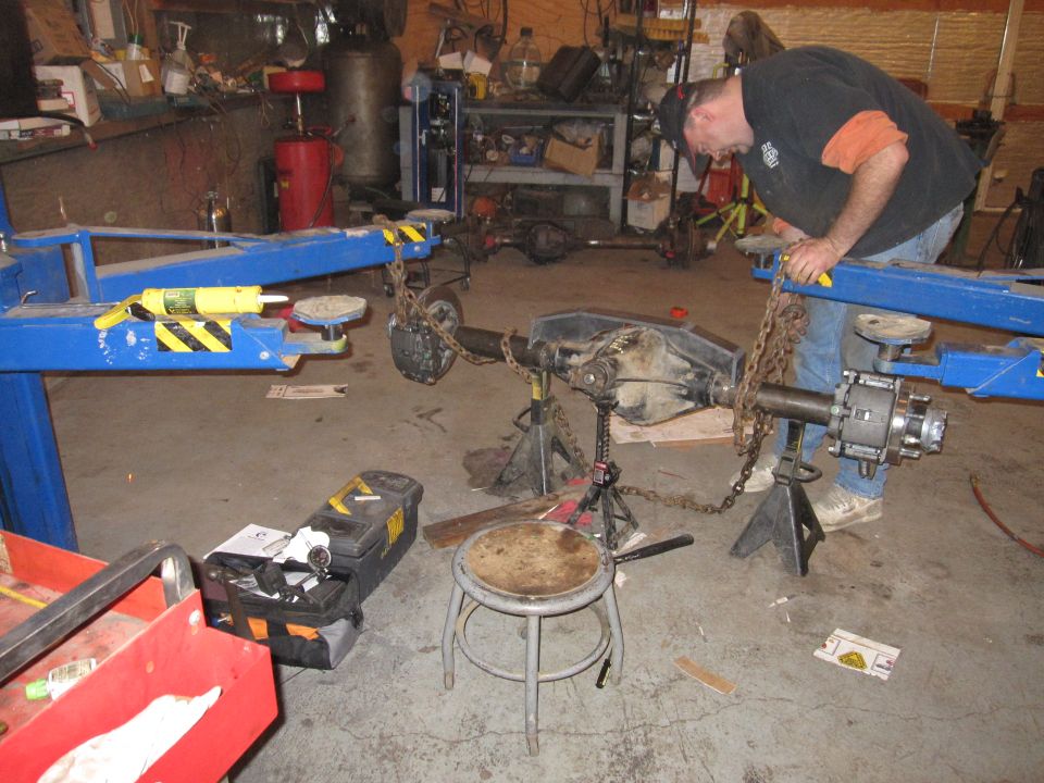Photo of a person working on an axle on a stand in a shop