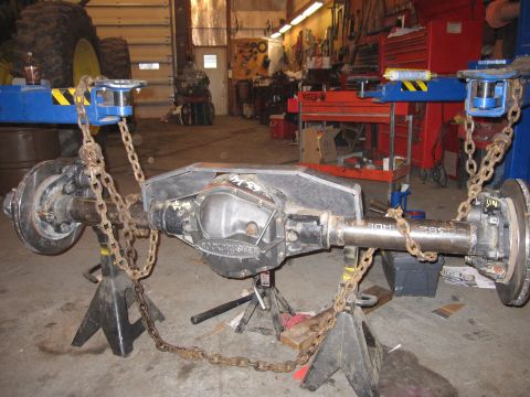 1992 Ford Bronco - Photograph of a vehicle front axle assembly supported on jack stands in a workshop, not a technical document.